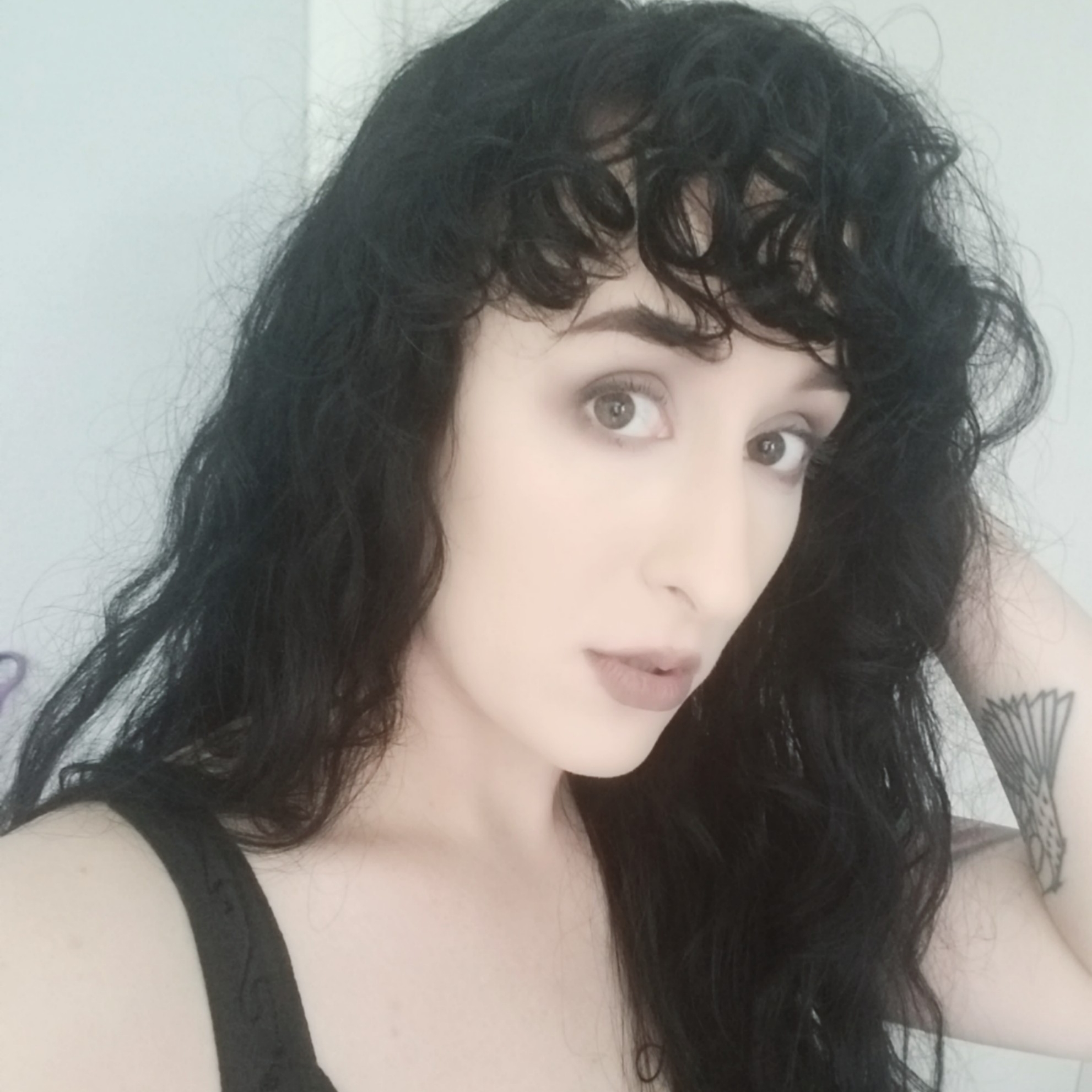 Image of Kathryne Grimm. A pale jewish person with long black curly hair. They're pretty.